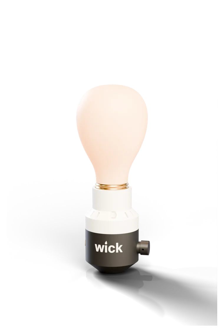 The wick socket in Tuxedo, white top and black base, holding a glowing bulb
